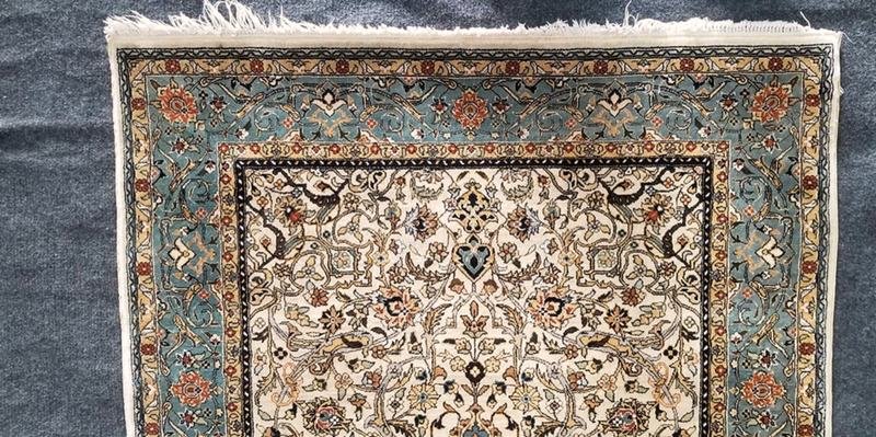 Franges effilochées et grisées sur la bordure d’un tapis en laine, avant reprise