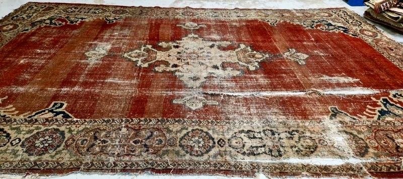 Grand tapis persan rouge au velours délavé et marqué par l’usure, avant restauration